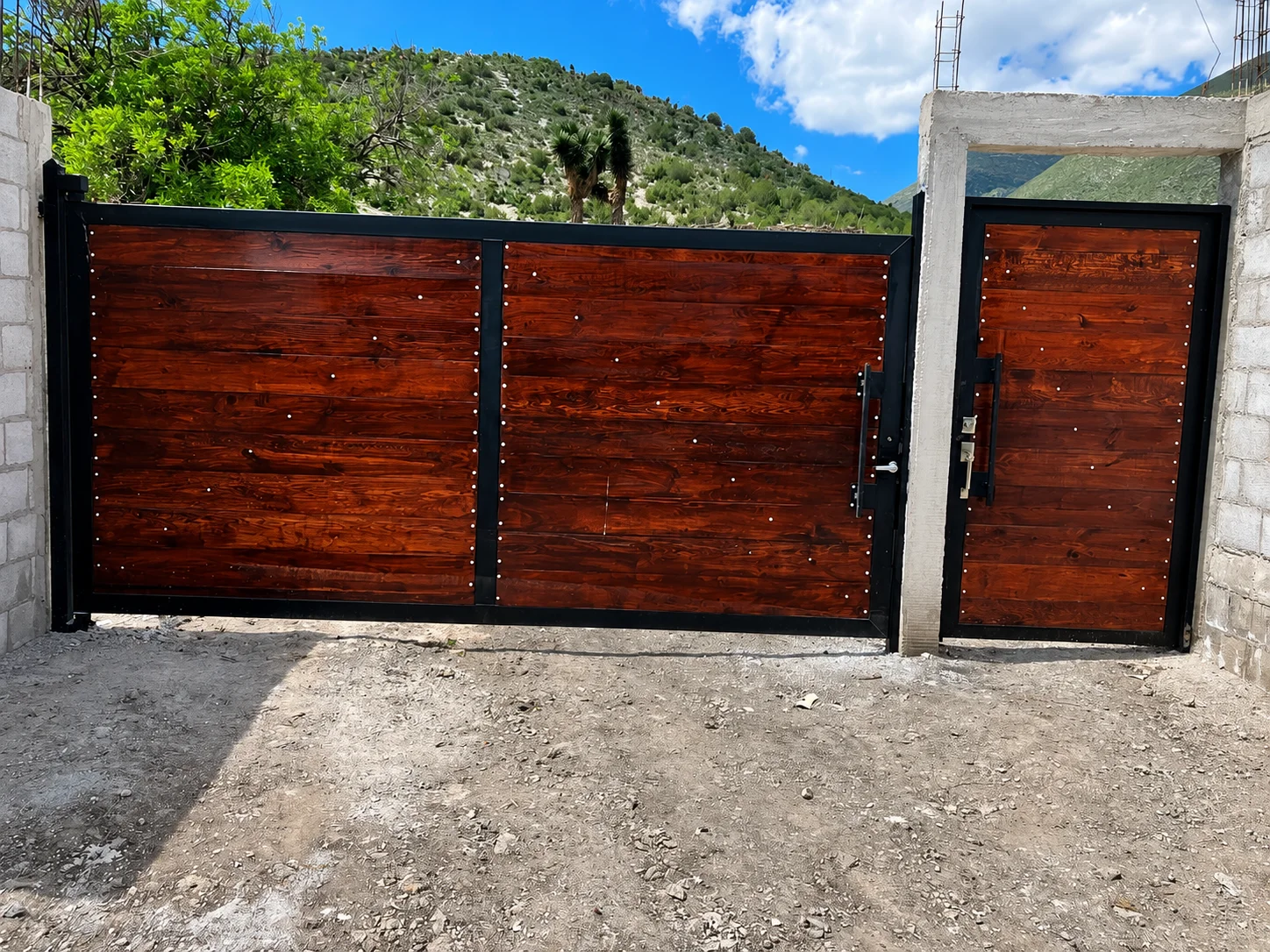 Portón metálico con acabado madera y puerta peatonal — EMET